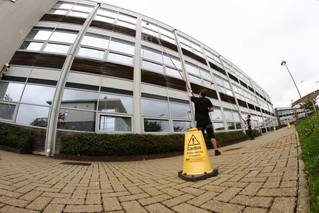 Window cleaner using extended pool to clean third story office building