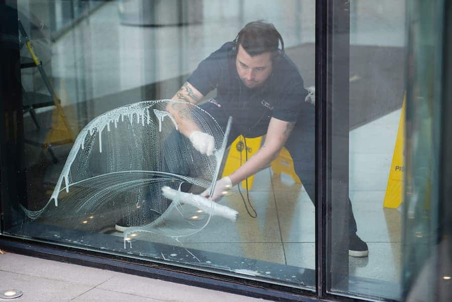 Worker Cleaning the Bottom of a Window