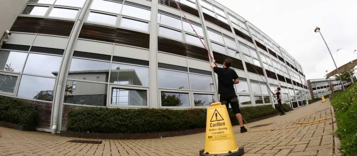 Window cleaner using extended pool to clean third story office building